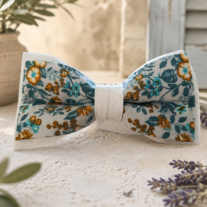 Nœud papillon Liberty Marcel Fleur Bleue en coton, motifs floraux bleu et ocre sur tissu écru upcyclé, présenté dans un décor provençal.