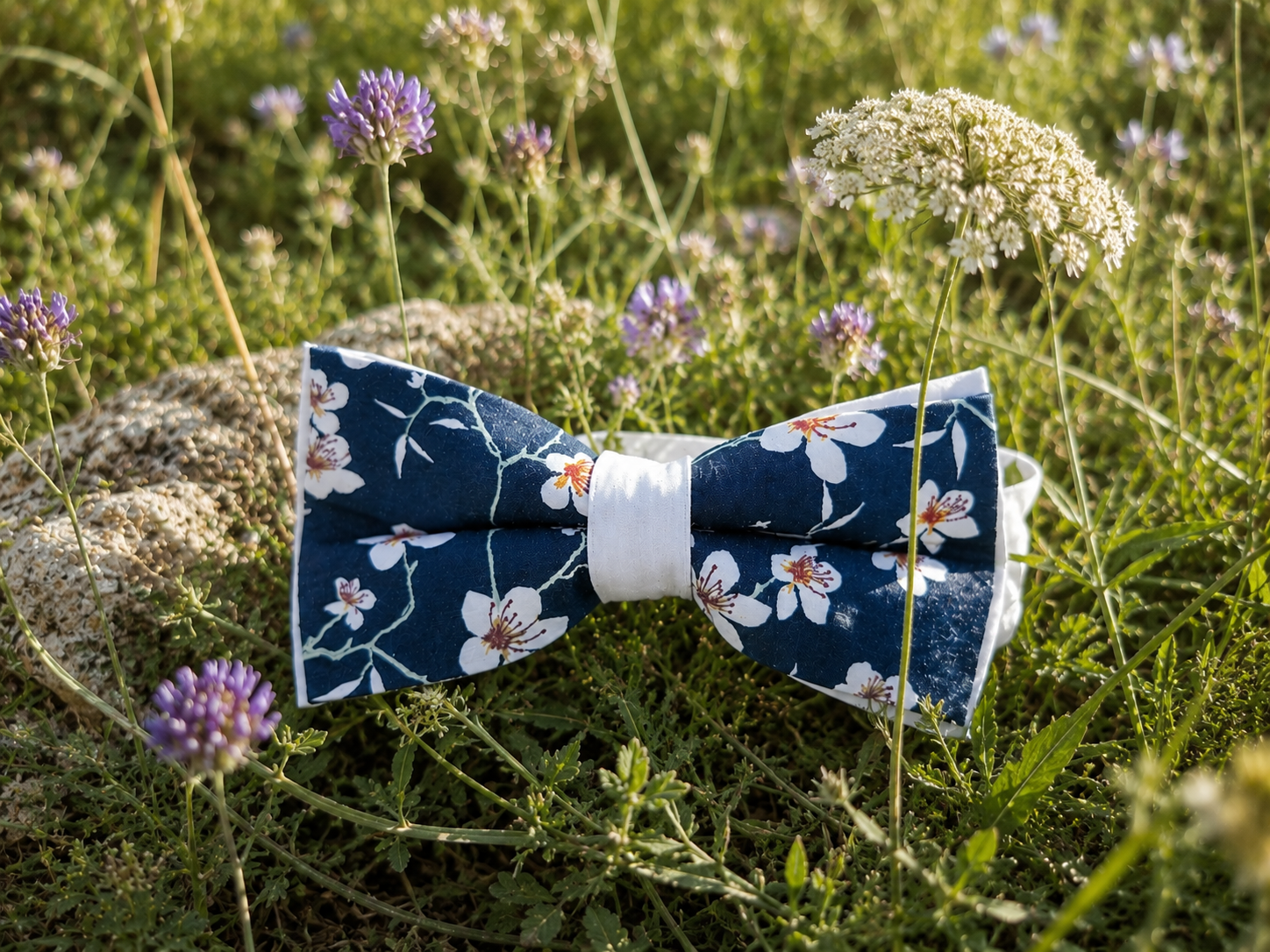 Nœud papillon Marcel Sakura photographié dans les fleurs sauvages du Gard à la lumière dorée de fin de journée.